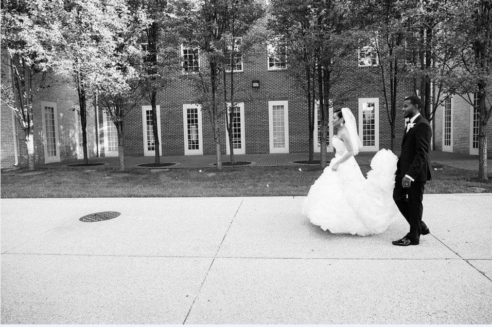 Newlyweds kissing with guests jumping in the background