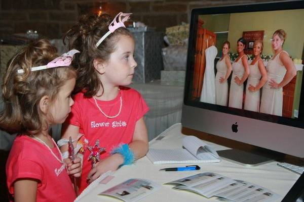 Flower Girls viewing pictures taken by Photos by Larry of the wedding day during the reception.