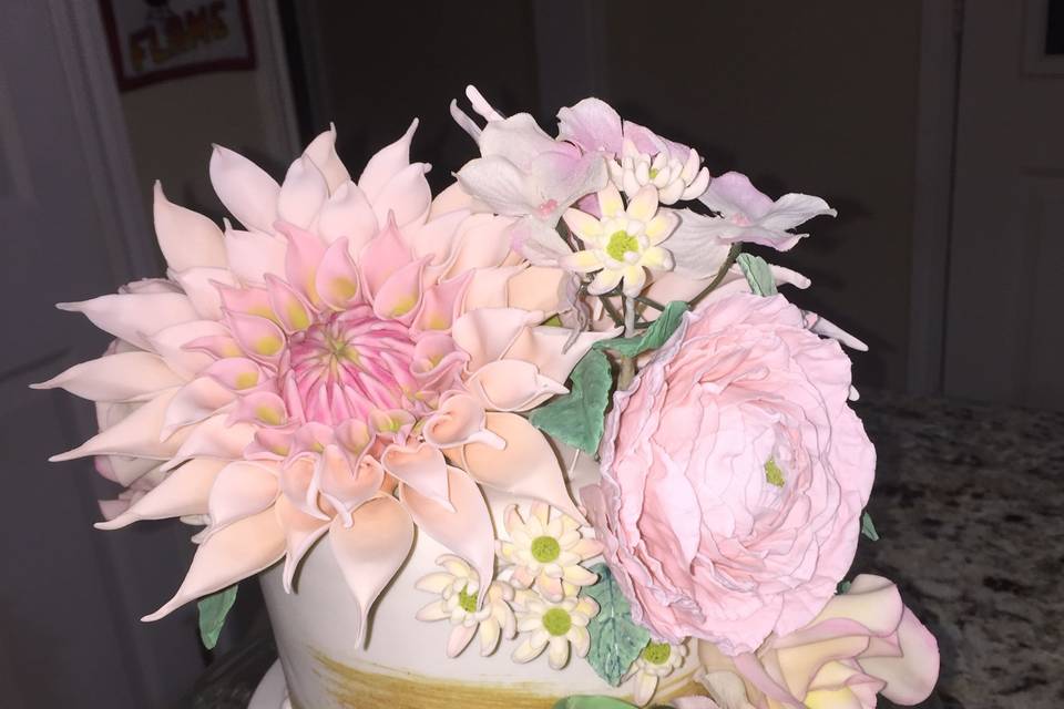 A small wedding cake and handmade sugar flowers