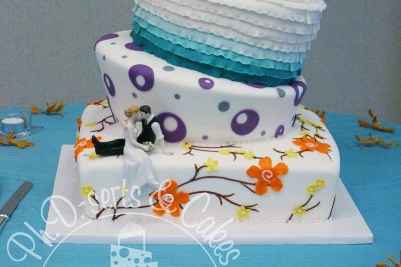A large topsy turvy wedding cake with many colors and themes all joined together into one cohesive cake! Don't be afraid to personalize your wedding cake!