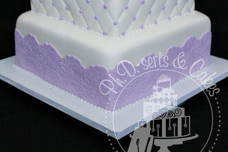 Cake covered in ivory fondant with lavender and white accents.  This cake would fit any wedding theme and the colors are easily interchangeable.