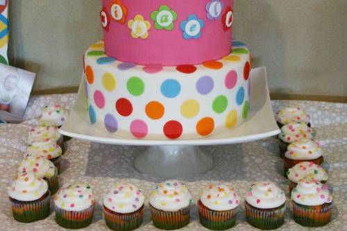 Rainbow-themed first birthday cake, cupcakes, and smash cake