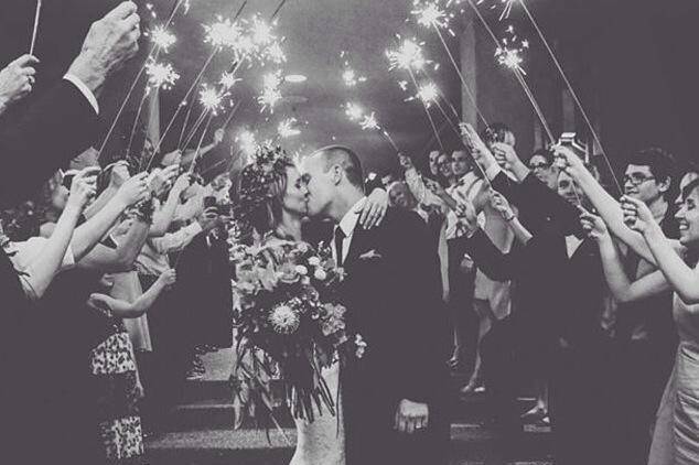 Couple kiss and guests hold sparklers