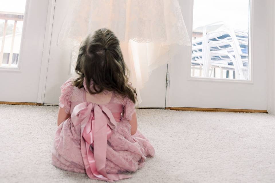 Flower Girl admires moms dress