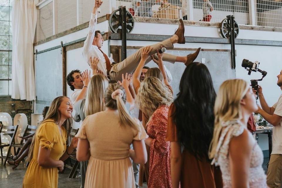 Groom being hoisted by groomsm
