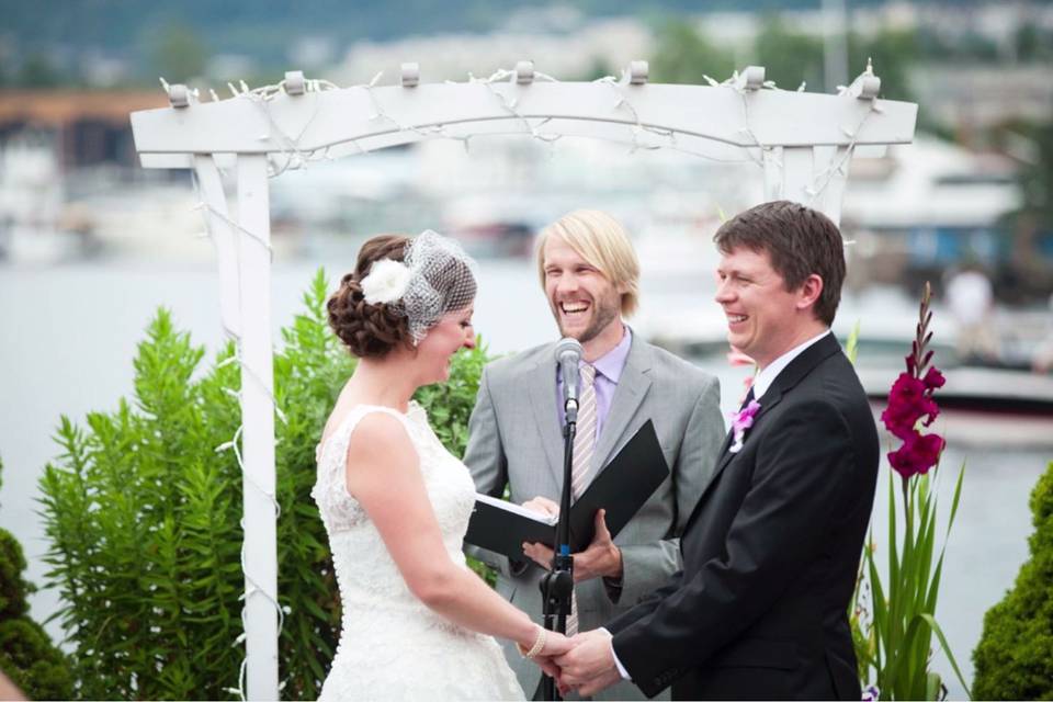 Officiant and newlyweds sharing a laugh