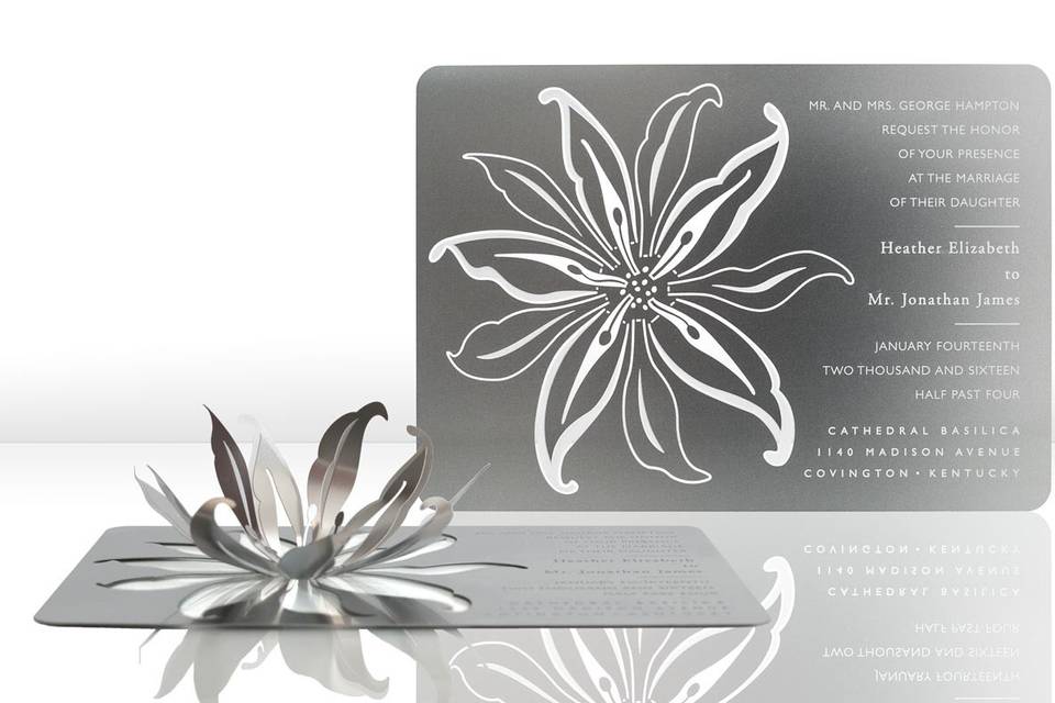 The LILY metal invitation sets the stage for a stunning, stately event, with an elegant, three-dimensional lily. Mails flat and is folded into a sculpture by guests. When folded, the invitation reveals a breathtaking metal lily that will spark memories of a sensational evening for years to come. Place a tea light next to it for beautiful, dancing shadows. Or use as home décor. LILY is also available as a favor with slits into which an escort card can be inserted.