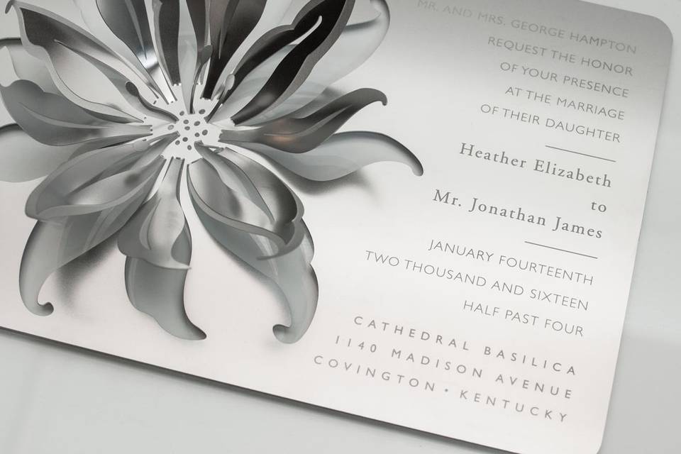 The LILY metal invitation sets the stage for a stunning, stately event, with an elegant, three-dimensional lily. Mails flat and is folded into a sculpture by guests. When folded, the invitation reveals a breathtaking metal lily that will spark memories of a sensational evening for years to come. Place a tea light next to it for beautiful, dancing shadows. Or use as home décor. LILY is also available as a favor with slits into which an escort card can be inserted.