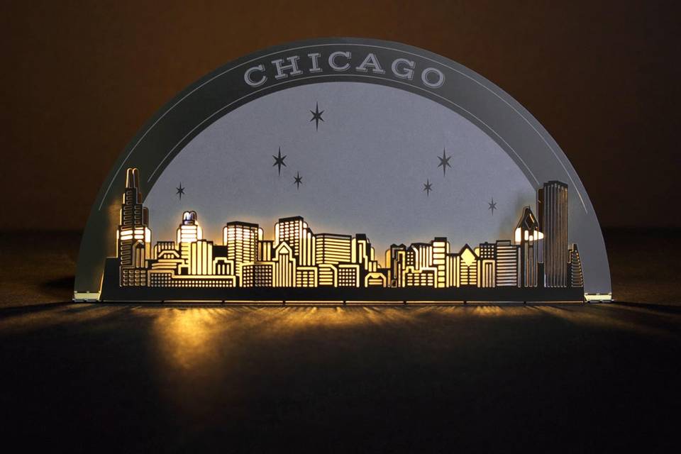 The CHICAGO SKYLINE metal invitation possesses gorgeous, accurate detail that will astonish your guests. Mails flat and is folded into a sculpture by guests. Folding the invitation at the perforations will reveal two layers of depth, with the skyline in front and the moon over Chicago behind. Place a tea light behind the sculpture and watch the skyline glow! Memories of a magical night in Chicago will live on forever with this invitation. CHICAGO SKYLINE is also available as a favor with slits into which an escort card can be inserted.