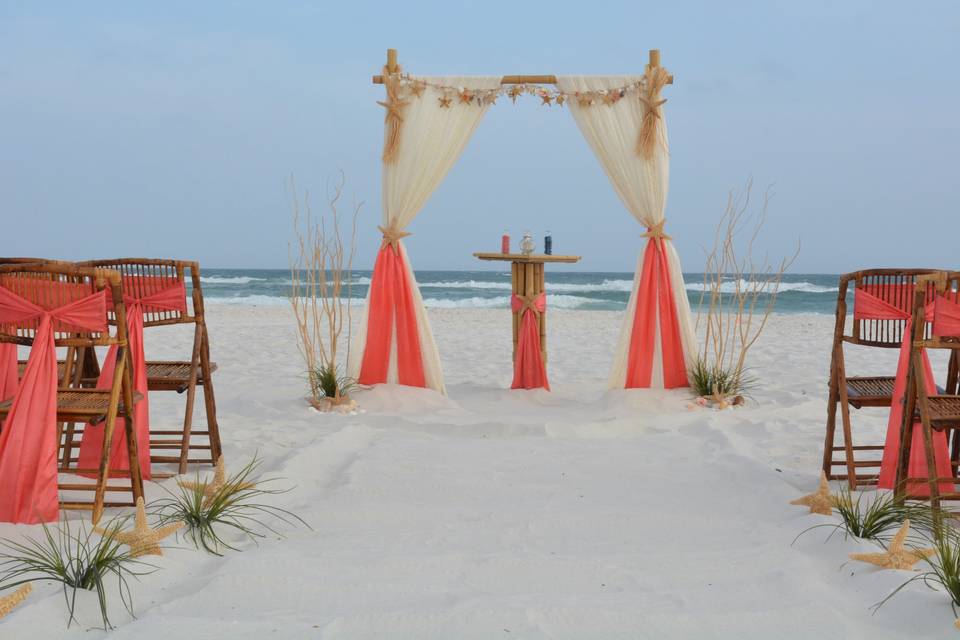 Simple barefoot wedding with 2 post arbor adorned with seashell garland