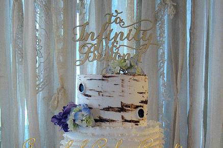 Naked wedding cake with purple flowers