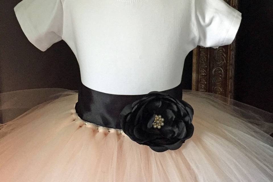 Blush skirt made from oodles and oodles of tulle.  Wide black satin ribbon sash is embellished with black flower with rhinestone center.  A lined white cotton leotard is included.
0-24 Months       $65
2t-5t                  $75
6-9                    $95
10-14                $105