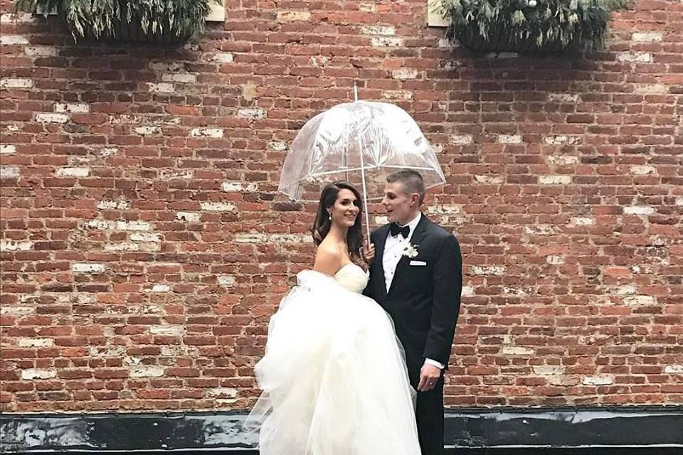 Newlyweds sharing an umbrella