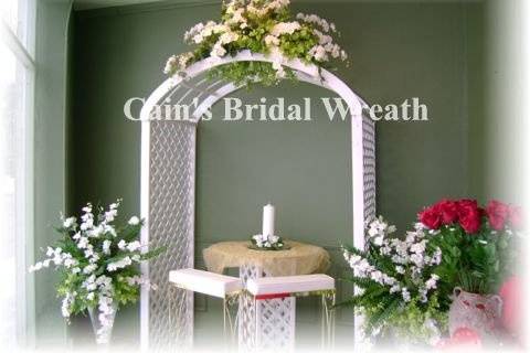 Wooden White Lattice Arch with white and soft green flowers. Two glass matching side arrangements