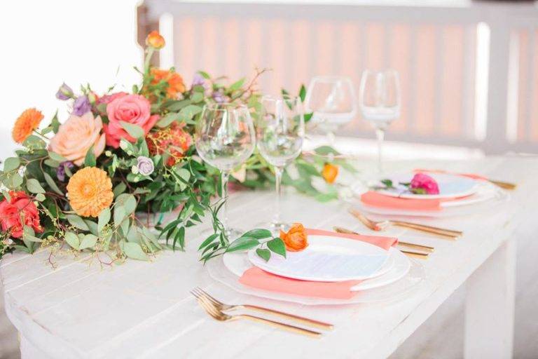https://cdn0.weddingwire.com/vendor/976181/3_2/960/jpg/color-of-the-year-coral-paradise-cove-wedding-a-chair-affair-farm-table-coral-napkin-gold-brushed-flatware-768x512_51_181679.jpeg