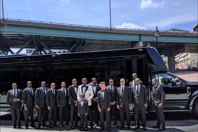 Groomsmen boarding stretch party bus