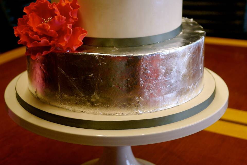 Silver leaf covered bottom tier with a beautiful red sugar flower for dramatic effect