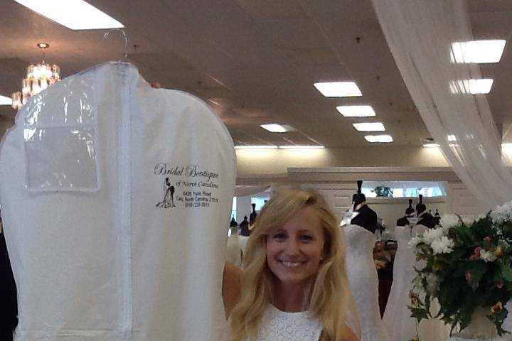 Bride-to-be holding up her purchased dress
