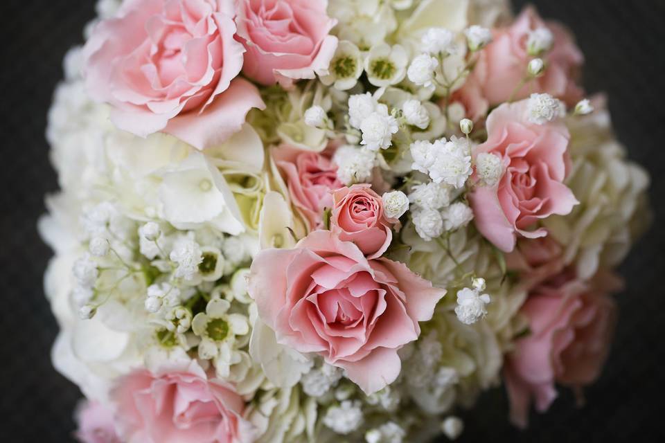 Bridesmaid bouquet in soft pinks and creams with pink spray roses, hydrangeas, wax flower and baby's breath.