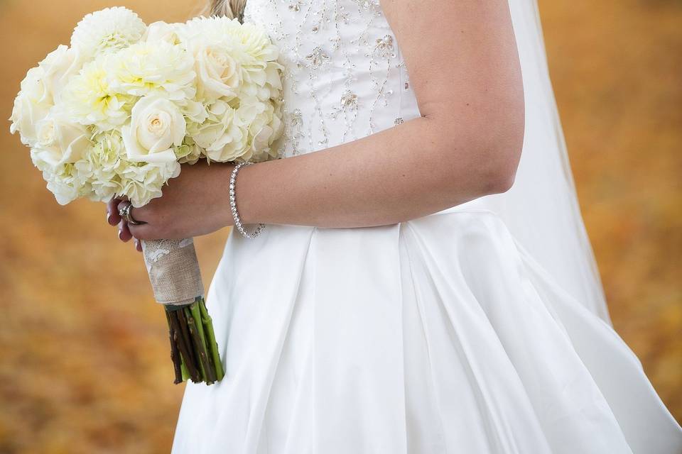 Bride with lush bridal bouquet in creams and whites with roses, hydrangea and dahlias.