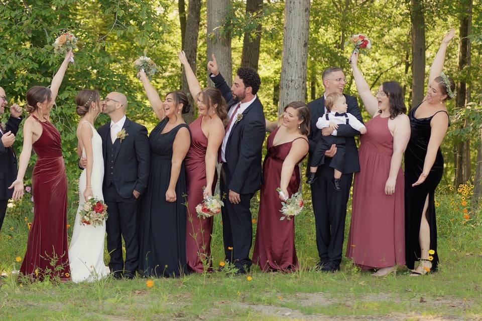 Bridal party cheers for kiss.