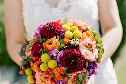 Cafe au lait dahlias, swamp lily, blue delphinium, blue hydrangea, ornamental grasses, and peach cabbage roses were used to create this bouquet. Photography by Carolina Photo Smith