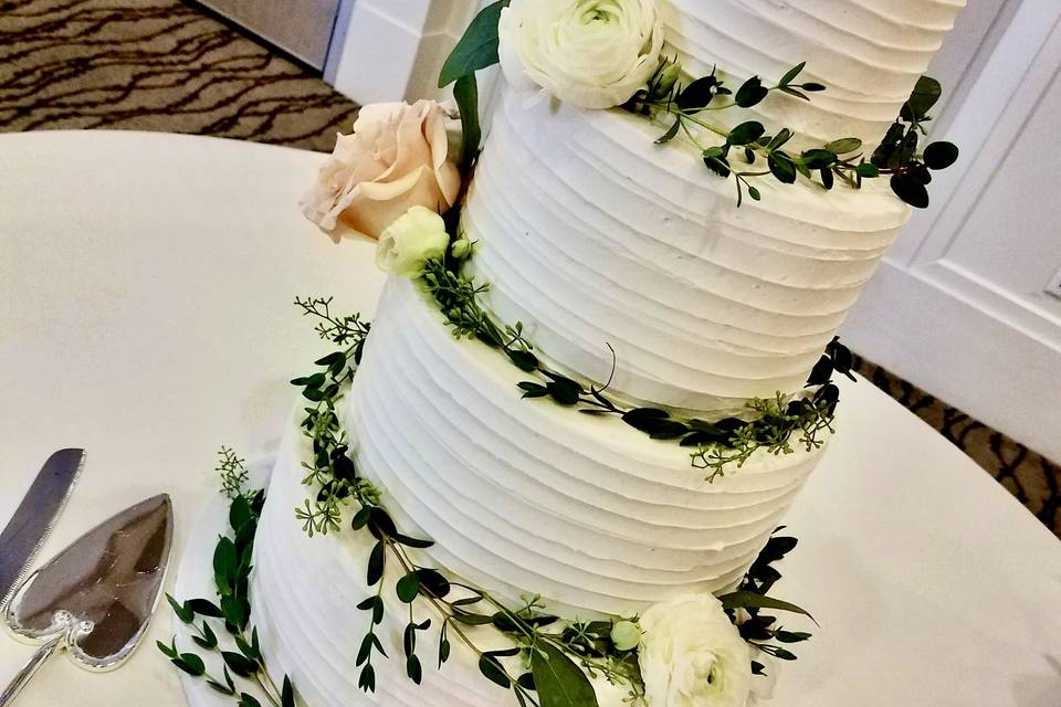 Greenery around tiered cake