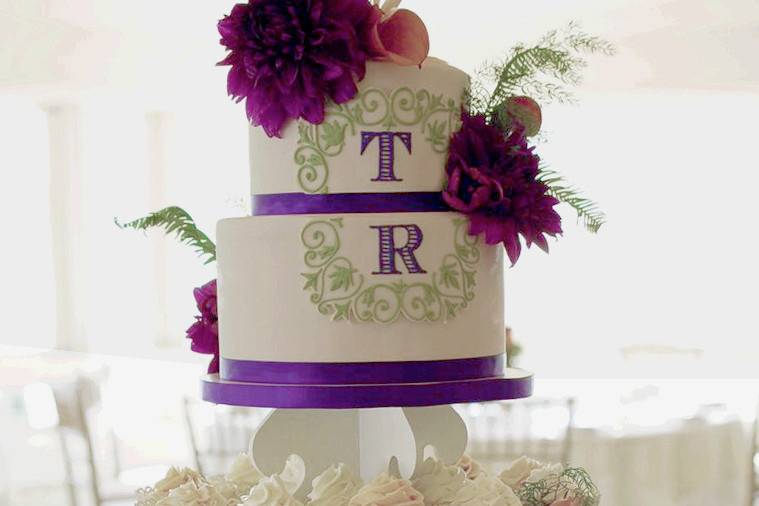 Ornate floral monogrammed cake tiers with cupcake tower
