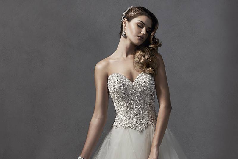 Chandra	<br>	Decadent Swarovski crystals and pearls adorn the bodice of this romantic ballgown, complete with voluminous tulle skirt and dramatic sweetheart neckline. Finished with crystal button over zipper and inner corset closure.