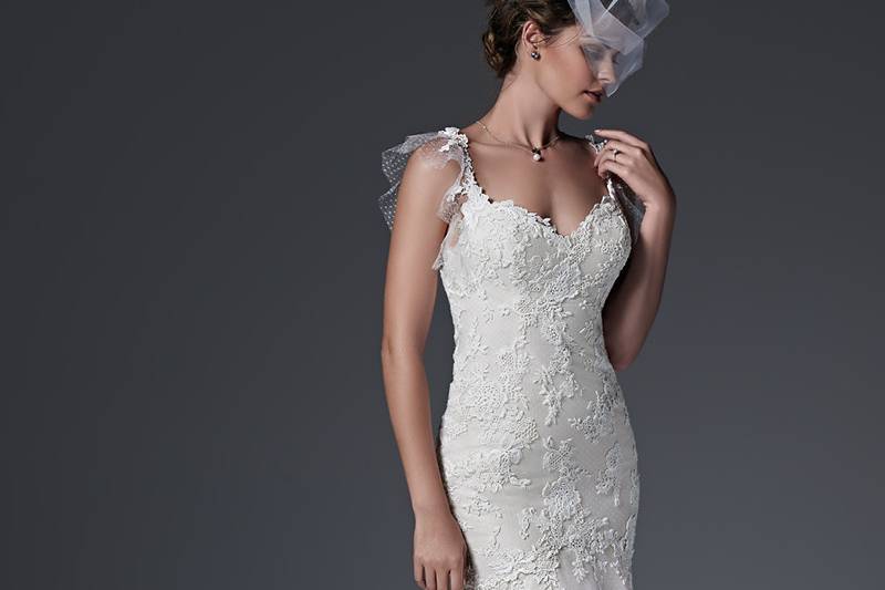 Style Elizabeth <br> Chic fit and flare wedding dress with floral lace appliqués drifting atop a dot tulle overlay, accented with a delicate illusion tulle back and flutter sleeves. Finished with dramatic, tiered train, sweetheart neckline and pearl buttons over zipper closure.