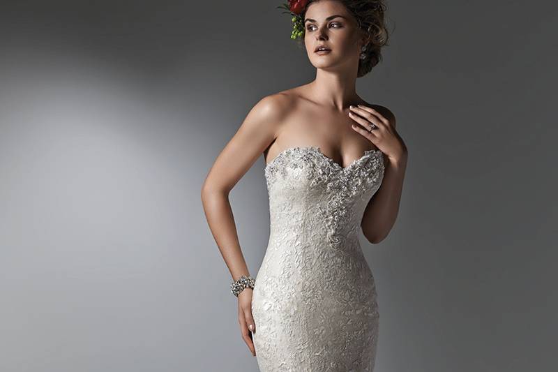 Style Gesinee <br> Exquisite painted lace glimmers in this fit and flare wedding dress, with a dramatic flared skirt and Swarovski crystal encrusted sweetheart neckline. Available with corset closure or crystal buttons over zipper and inner corset closure.