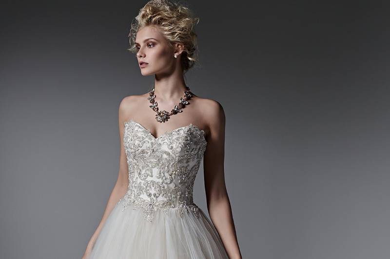 Style Layla <br> Whimsical layers of tulle create the skirt of this romantic ball gown wedding dress, while sparkling Swarovski crystals, pearls and beads adorn the bodice. Finished with sweetheart neckline and corset closure.