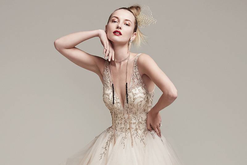 Amelie<br> Dione organza creates a dramatic ball gown with horsehair layered skirt, featuring a breathtaking bodice adorned with Swarovski crystals and pearls, plunging illusion V-neckline and back. Finished with crystal buttons over zipper closure.
