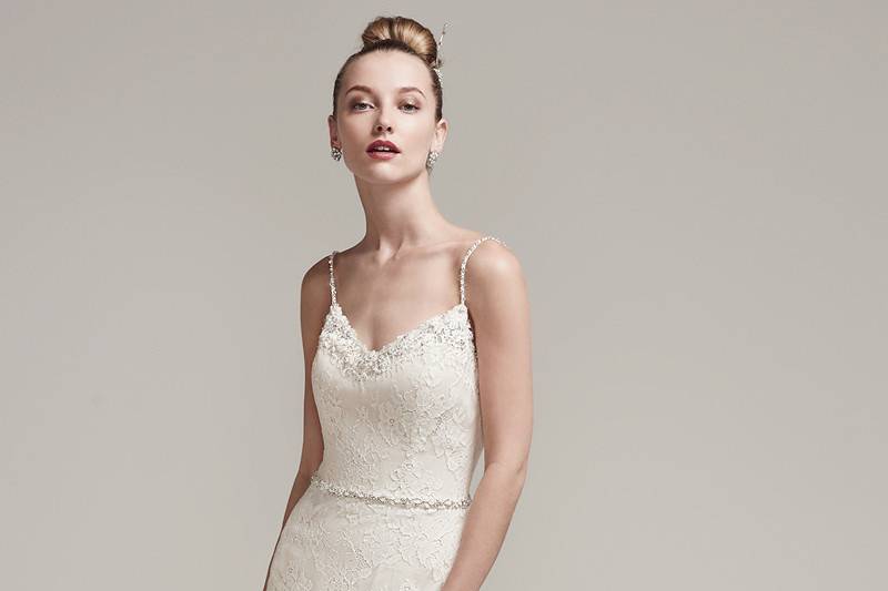 Ester<br> Allover lace sheath wedding dress accented with beaded spaghetti straps, sexy illusion neckline and V-back. Finished with a beaded belt featuring Swarovski crystals and covered buttons over zipper closure.