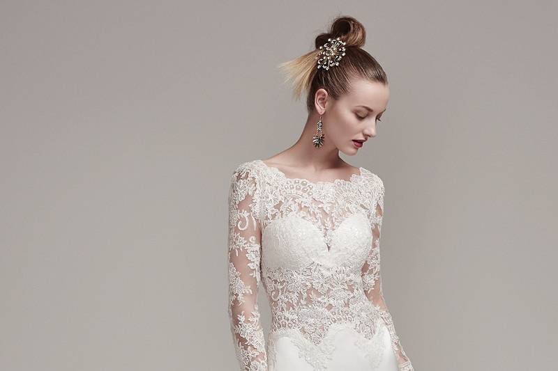 Fiona Rose <br> Illusion lace accented with a stunning scalloped lace bateau neckline and long sleeves adds chic sophistication to this Belize satin sheath wedding dress, complete with a detailed illusion lace trimmed train and ruching. Finished with covered buttons over zipper closure.