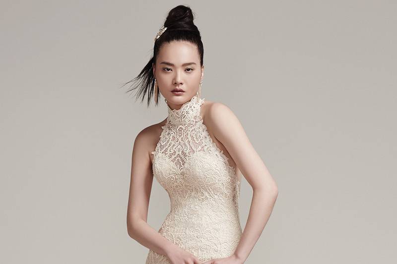 Hunter <br> This modern allover lace sheath wedding dress features sexy elements including a statement-making illusion lace halter neckline and daring open back with illusion lace strap. Finished with covered buttons over zipper closure.