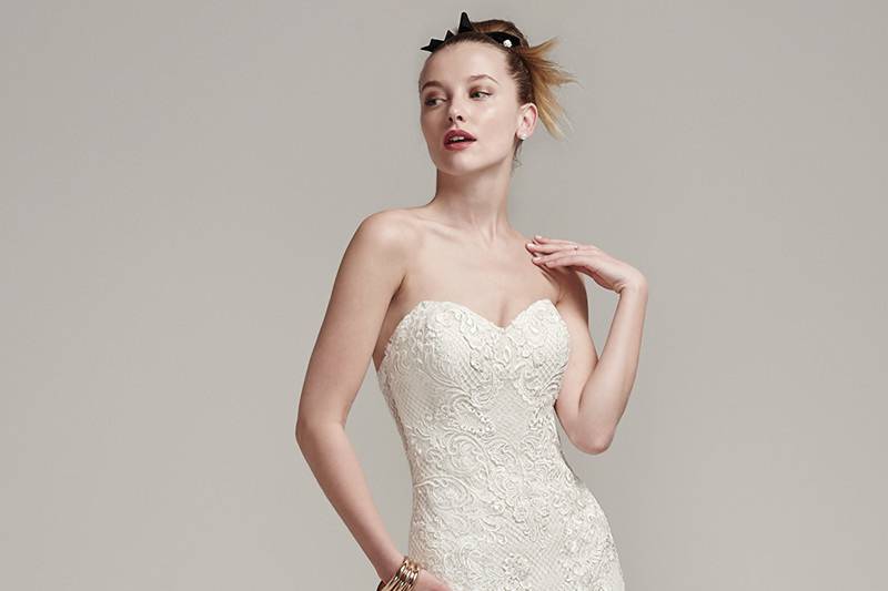 Leona <br> Stunning lattice tulle meets modern lace embroidery, creating a stunning fit and flare wedding dress, complete with sweetheart neckline and intricate lace hemline and train. Finished with illusion back and pearl buttons over zipper closure.