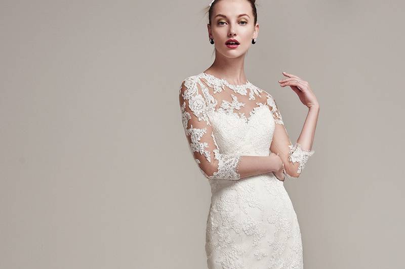 Moriah<br> Lace motifs add sophisticated elegance to this fit and flare wedding dress, featuring a strapless sweetheart neckline and layered Fallow organza skirt and train. Complete with crystal buttons over zipper and inner corset closure. Also available, an illusion lace bodysuit with three-quarter length sleeves. Bodysuit sold separately.