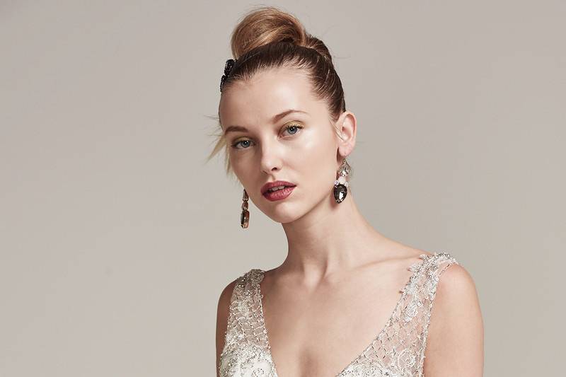 Ronnie <br> Swarovski crystals and metallic threads are artistically woven onto this tulle sheath wedding dress with illusion lace straps and plunging V-neckline. Complete with plunging illusion back and crystal buttons over zipper closure.