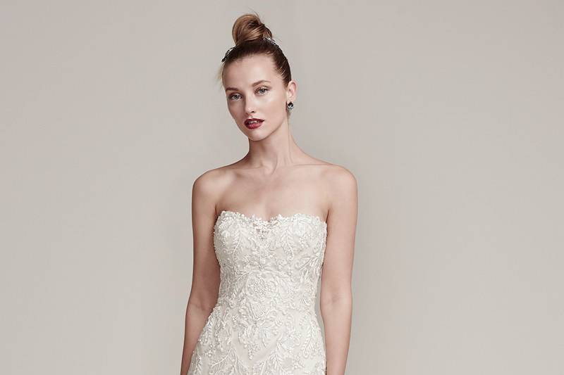 Tessa<br> Exquisite embroidered lace covers this sophisticated fit and flare wedding dress, embellished with Swarovski crystals and beads. Complete with an illusion sweetheart neckline and scalloped lace hemline flowing into an elegant train. Finished with crystal buttons over zipper and inner corset closure.