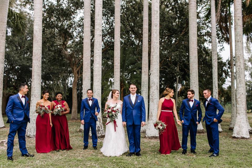 Wedding party standing under trees