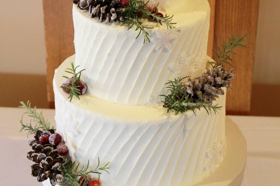 Three tier buttercream diagonal spatula pattern adorned with acorn and fresh berries