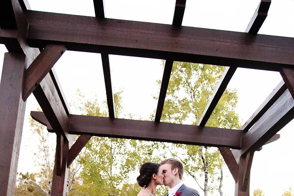 Couple's kiss under arbor