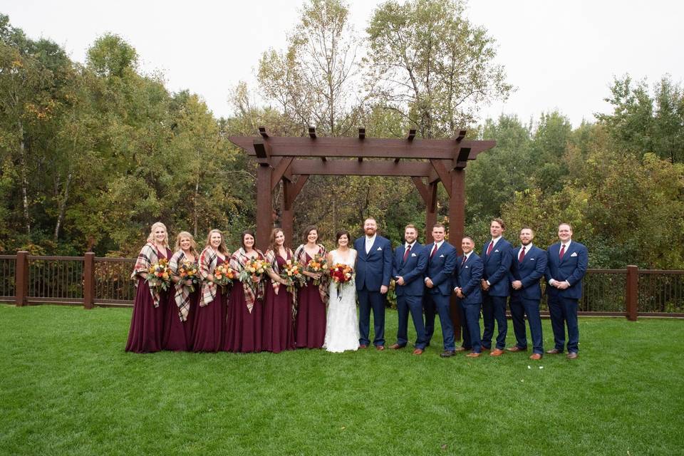 Bridal party in front of arbor