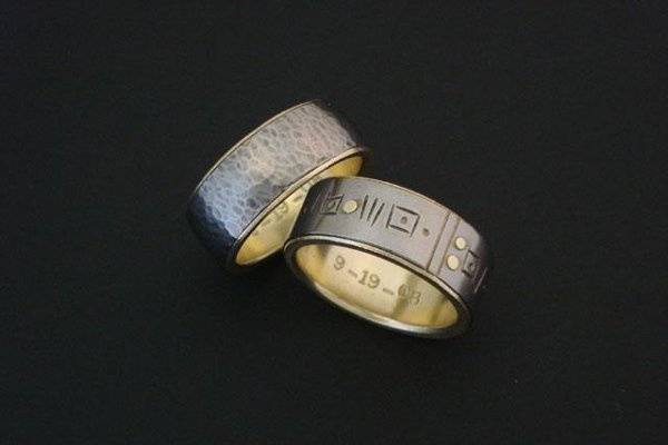 Jay and Mark both wanted Titanium bands with 18k yellow gold liners, so the rings reference each other, however, they both had distinctive design styles that were different.  So, here we have their bands that speak directly to their individuality, while symbolizing their union with matching materials.