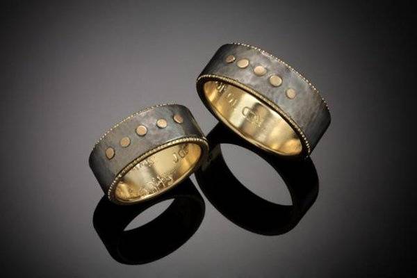Jeff and Robin have actually been married for years.  I created these rings for their anniversary.  They are made of a hammered textured Titanium with 18k yellow gold liners and 5 gold rivets that represent their children.  I added the coin edge texture to the liner to give a little more layering and edge.