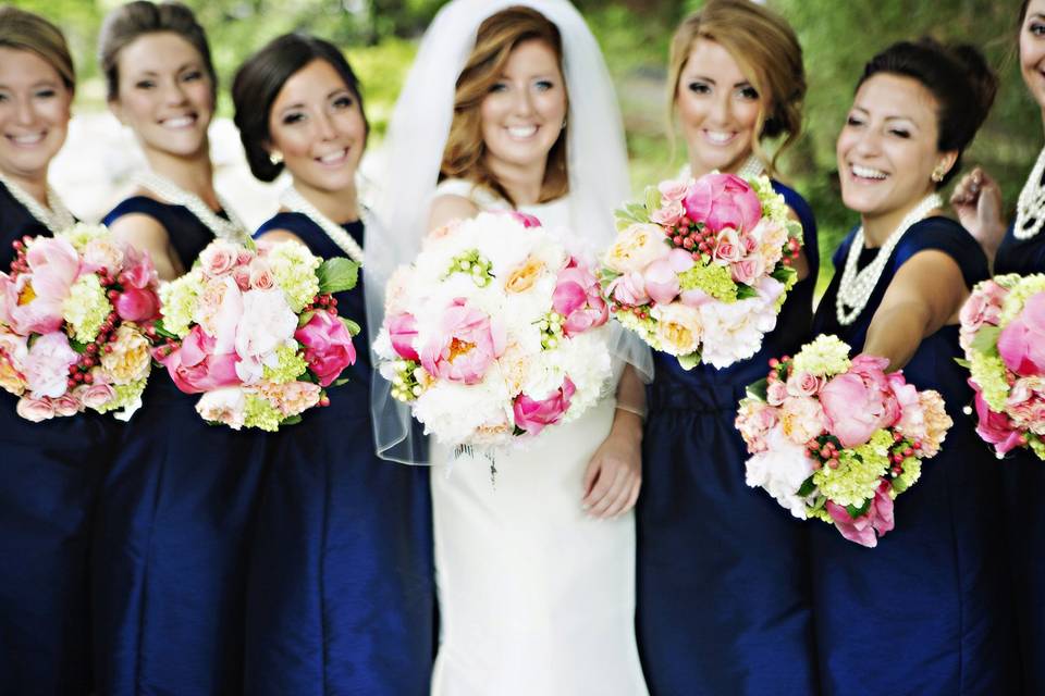 Bride with bridesmaids holding flower