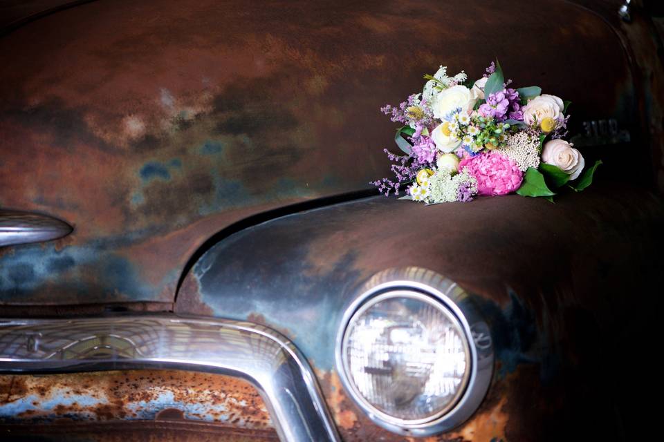 Bridal bouquet on the rustic car