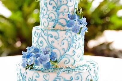 Three tier white and blue cake with embellishments