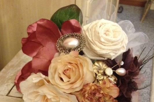 Vintage brooch bouquet with authentic old brooches, the finest of silk flowers, hand - made fabric roses, tulle, antique rose lace and chocolate brown satin wrapped handle with silk tassels, and authentic silk flowers from yesteryear. Topped off with silk peacock feathers...